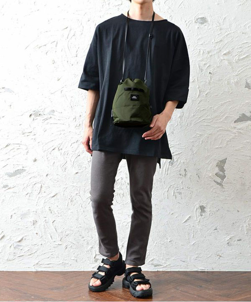 暗色コーデにはカーキバッグが馴染む