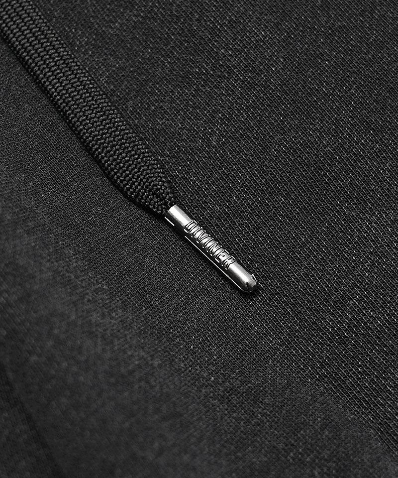 ブランドロゴが刻印された金属チップ付きウエストドローコードと、ヴィンテージ感漂う生地の寄り画像。